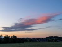 Aus dem orangeleuchtenden Wolkenhaufen ist ein rötliches Wolkenschiff geworden